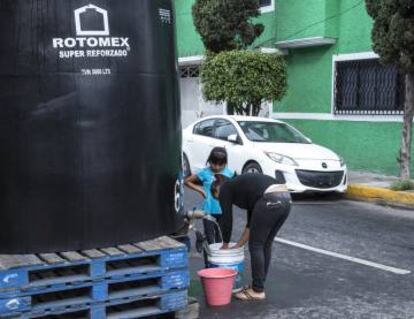 Vecinos de Ciudad de México llenan cubos en uno de los puntos de suministro.