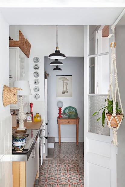 La cocina. El mueble colgado arriba es el que había originalmente y fue restaurado y pintado. “El resto son muebles que vienen de aquí y de allá y se han ido encajando casi como un tetris”, explican los autores. La cabeza de toro de paja proviene de Cabo de Gata, lugar en el que la familia suele veranear. Los platos en la pared son de cerámica de Bjørn Wiinblad.