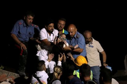 Un terremoto ha sacudido la noche lunes la isla italiana de Ischia, con un balance provisional de dos muertos y 39 heridos. En la imagen, un agente de los Carabinieri y un médico transportan a un niño.