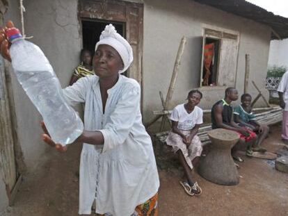 Mulher lava as mãos com água clorada, medida de prevenção contra o ebola, em Serra Leoa.