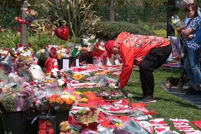 Un aficionado deposita una tarjeta en el memorial del recientemente fallecido Diogo Jota.