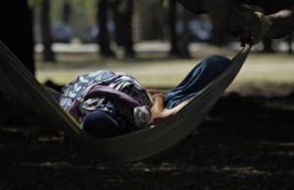 Una mujer descansa en una hamaca a la sombra de un árbol para mitigar el calor en los bosques de Palermo, en Buenos Aires. EFE/Archivo