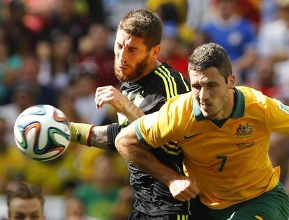Sergio Ramos (i) y el jugador australiano Matthew Leckie chocan durante una carrera por hacerse con el balón.