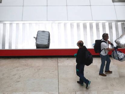 Dos pasajeros recogen su equipaje ayer, 12 de mayo, en el aeropuerto de Madrid-Barajas.