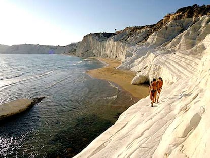 Dos bañistas pasean por las terrazas calcáreas de la Scala dei Turchi, al sur de la isla de Sicilia, cerca de Agrigento.