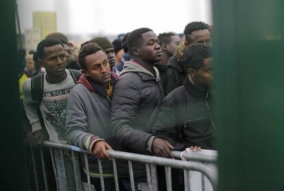 Migrantes esperan su turno antes de ser registrados para abandonar el campamento de Calais (Francia).