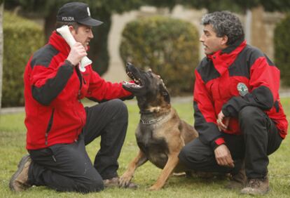 Dos agentes de la Ertzaintza juegan en la Academia de Arkaute con uno de los perros especializado en rescates.