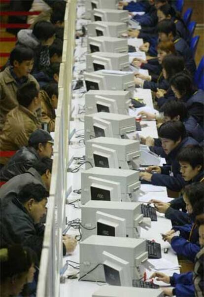 Viajeros chinos adquieren billetes para el ferrocarril en unas taquillas de Shanghai.