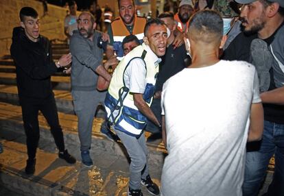 Al menos 205 palestinos y 17 policías israelíes han resultado heridos en la noche del viernes en choques con la policía en la mezquita de Al Aqsa de Jerusalén, tercer lugar sagrado del islam, según informó la Media Luna Roja palestina, que montó un hospital de campaña en la explanada del recinto. En la imagen, traslado de un herido palestino durante los enfrentamientos con las fuerzas de seguridad.