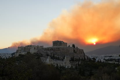 El templo del Partenón, en la cima de la colina de la Acrópolis de Atenas, con humo del gran incendio forestal en Varnava, a unos 40 kilómetros, este lunes.