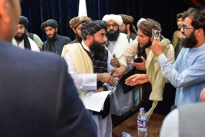 El portavoz talibán Zabihullah Mujahid abandona la sala de prensa este martes 17 de agosto mientras le sacan una foto. El líder afgano ha aprovechado la conferencia para quejarse de la censura de Facebook.