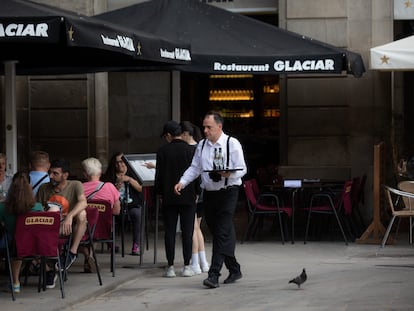 Un camarero sostiene una bandeja en la plaza Real de Barcelona.