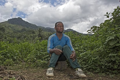 Mapenzi, sentado en su aldea. Al fondo, las montañas 