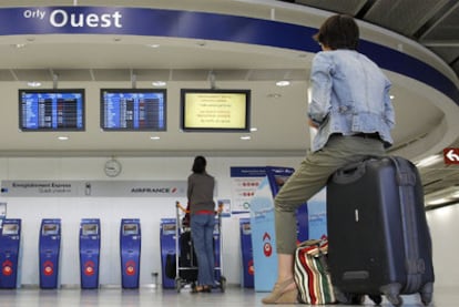 Dos pasajeras en el aeropuerto de Orly, en París, se informan ante el panel de vuelos.