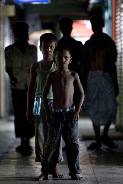 Dos niños mendigos, de noche, por las calles de Bangladesh.