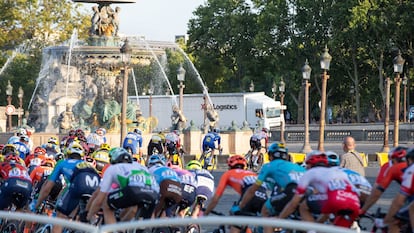 El pelotón del Tour, junto a un camión de la organización.