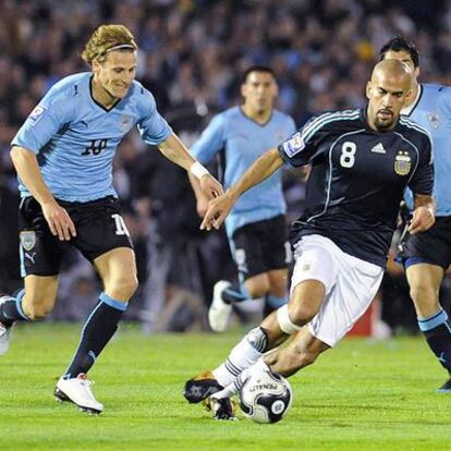 Forlán persigue a Verón durante el partido de ayer en Montevideo.