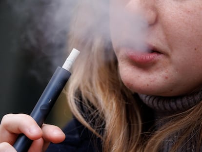 A teenager vapes in London in March.