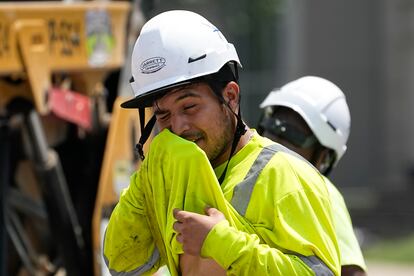 Construction worker Fernando Padilla wipes his face as he works in the heat, Friday, June 30, 2023 in Nashville, Tenn.