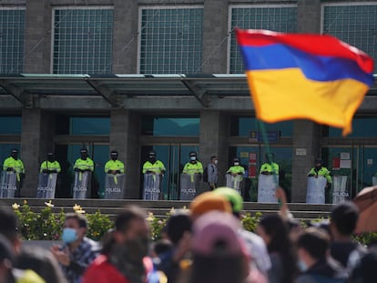 Manifestantes frente al edifico de la Fiscalía, resguardado por policías, en Bogotá.