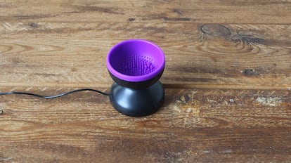 Limpiadores para brochas de maquillaje sobre una mesa de madera.