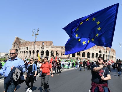 Un hombre ondea una bandera de la Unión Europea frente al Coliseum de Roma.