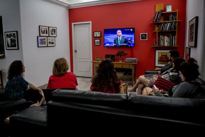 Varias personas presencian este domingo en su hogar, en São Paulo, el debate entre los dos candidatos presidenciales.