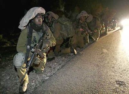 Un pelotón de soldados israelíes toma posiciones anoche junto a una carretera de Gaza.