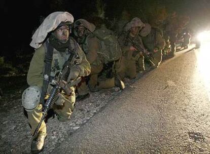 Un pelotón de soldados israelíes toma posiciones anoche junto a una carretera de Gaza.