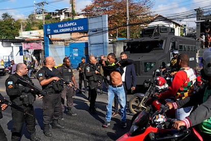 Durante una protesta de chóferes de moto-taxi contra la acción policial, un hombre se levanta la playera para mostrar que no va armado, este jueves en la favela Alemão, Rio de Janeiro.