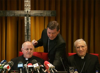 Martínez Camino prepara los micrófonos a Blázquez mientras sonríe Rouco Varela, en la apertura de la asamblea de los obispos de esta semana.