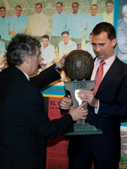El príncipe Felipe sostiene un balón que se utilizó en el primer mundial celebrado en Uruguay en 1930 ante Ángel María Villar.