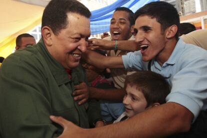 Hugo Chávez con alumnos en una escuela ayer en su duodécimo aniversario como presidente.