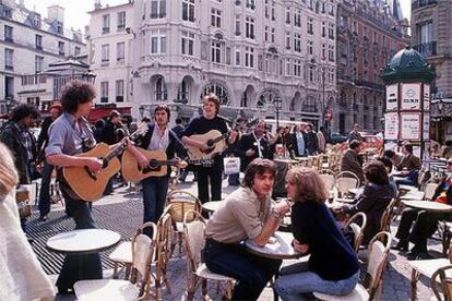 Unos músicos tocan ante los clientes de un café en París.