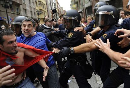 Dos miembros de Stop Desahucios forcejean con la policía durante las protestas