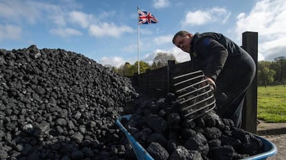 Un trabajador acarea carbón en una feria de máquinas de vapor en Hollycoombe (Inglaterra).