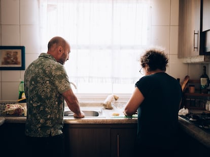 una pareja en la cocina de su casa. Derechos de la mujer