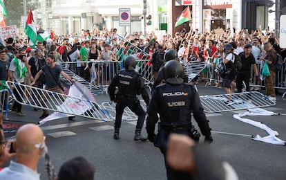 Manifestantes propalestinos tiran las vallas de seguridad de la Vuelta a la altura de Callao ante varios policías.