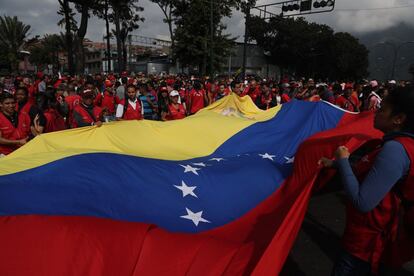 Afines a Maduro ondean una bandera nacional en una de las marchas oficialistas convocadas en la capital venezolana.