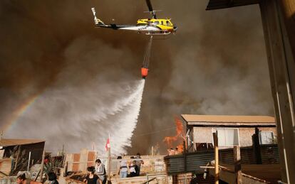 El director de la Oficina Nacional de Emergencia (Onemi), Ricardo Toro, ha afirmado que hasta el momento no se han registrado víctimas a causa del incendio, aunque 16 viviendas han sido afectadas. En la imagen, un helicóptero arroja agua sobre las llamas.