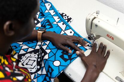 Diop cosiendo una de sus prendas en su casa taller.