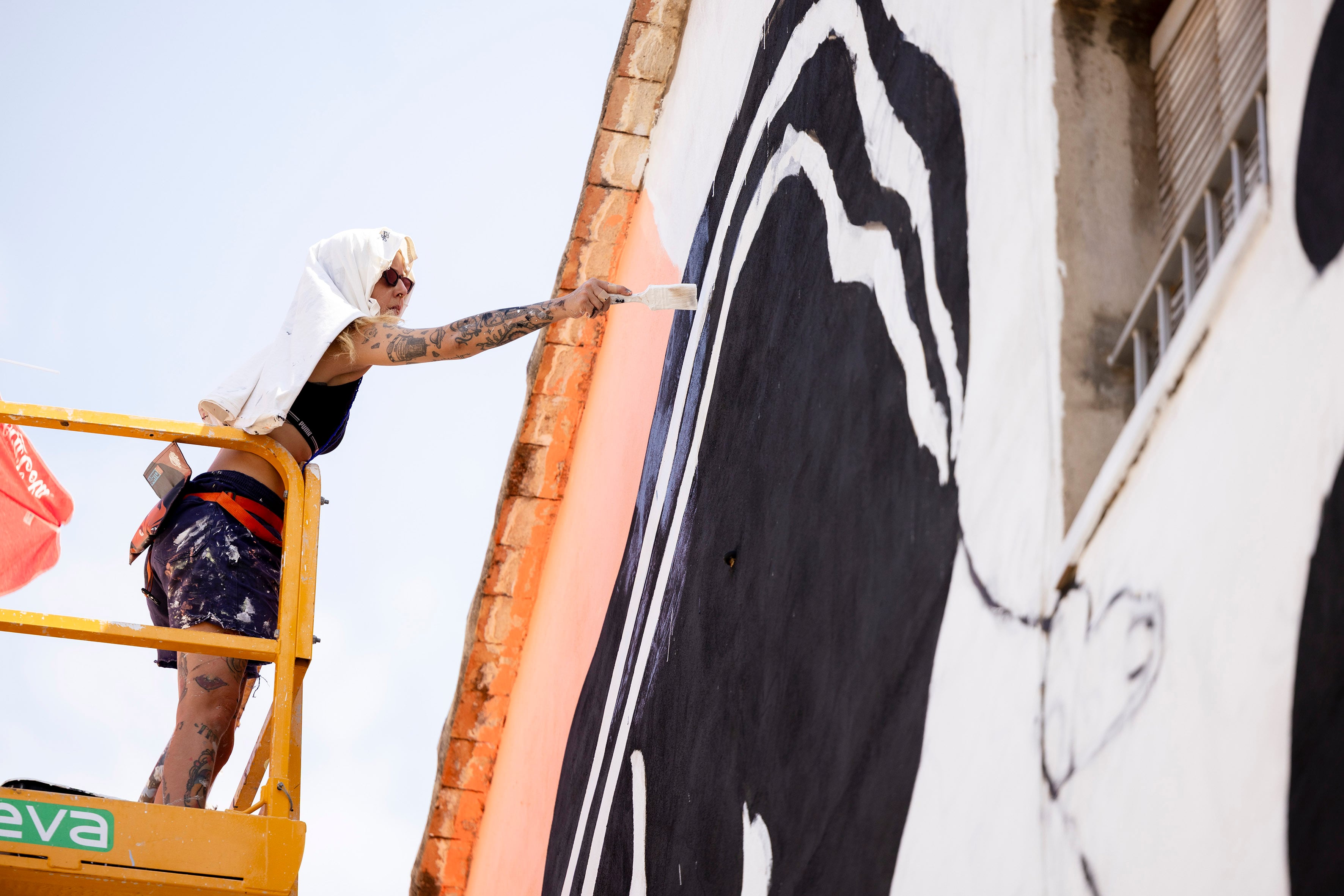 La artista Marie Balbinot pinta un mural en Fanzara, en Castellón, durante el festival de arte urbano MIAU.