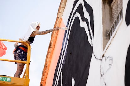 La artista Marie Balbinot pinta un mural en Fanzara, en Castellón, durante el festival de arte urbano MIAU.