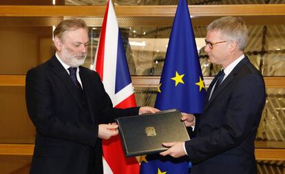 El embajador británico en la UE, Tim Barrow (izquierda), entrega los documentos que ratifican el Brexit al secretario general del Consejo, Jeppe Tranholm-Mikkelsen, este miércoles en Bruselas.