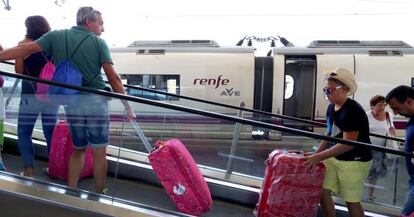 Travelers alight an AVE train in Madrid's Atocha station.