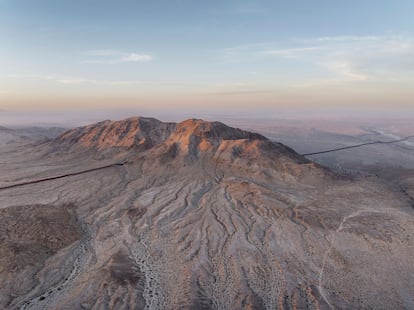 Las últimas luces del día iluminan una montaña donde el muro fronterizo se interrumpe, a la altura de La Rumorosa. Pese a lo hostil del terreno y la presencia de delincuentes, miles de migrantes atraviesan el desierto con la esperanza de llegar a Estados Unidos, demostrando que la gran obra de ingeniería que es el muro y su altísimo coste económico no funcionan.