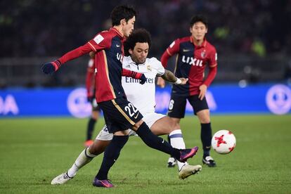 Daigo Nishi, del Kashima Antlers, compite por el balón junto con Marcelo del Real Madrid.