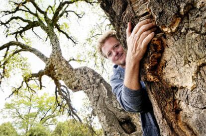 Juan Luis Cano se abraza a uno de los árboles del paraje protegido que ha ayudado a salvar en Torrelodones