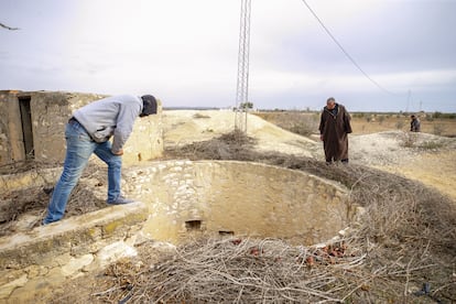 Dos vecinos de Sisib, en Túnez, miran al fondo de un pozo seco en marzo de 2022.