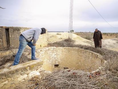 Dos vecinos de Sisib, en Túnez, miran al fondo de un pozo seco en marzo de 2022.